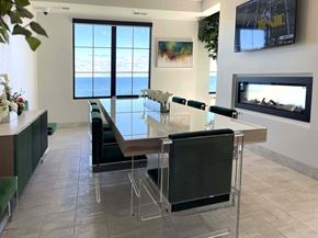 St Francis apartment for rent - a dining room with a glass table and chairs and a fireplace at 42 Hundred On The Lake, St Francis, WI