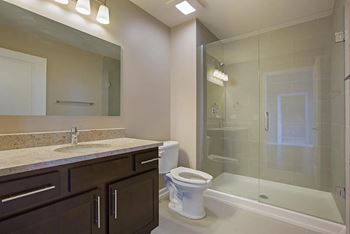 Luxury bathrooms with oversized soaking tub, granite countertops, and stylish vanity lighting