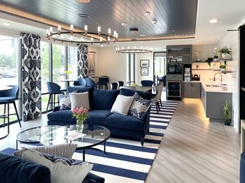 A living room with blue couches and a glass coffee table