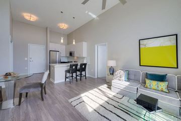 Lombard apartment for rent - A modern living room with a grey sofa and a glass coffee table.