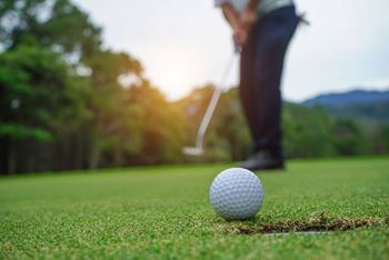 A golfer teeing off at a golf course