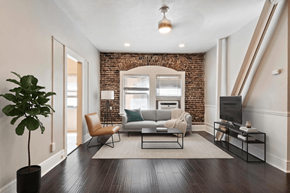 Pasadena apartment for rent - A living room with a brick wall and a grey couch.