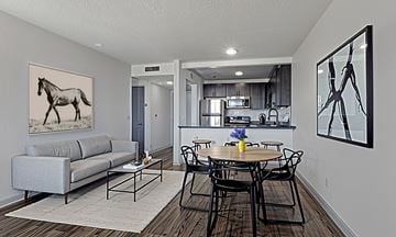 Nashville apartment for rent - A living room with a grey couch and a painting of a horse on the wall.