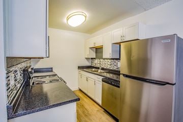 Las Vegas apartment for rent - A kitchen with a stainless steel refrigerator and a black countertop.