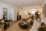 Las Vegas apartment for rent - Fifteen 50 Apartments living room staged with a white couch, a coffee table, and a television.