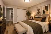 Las Vegas apartment for rent - Fusion Las Vegas bedroom with a bed, bench, and two framed artworks on the wall, a bed, and a closet with white doors.