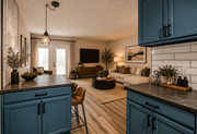 Las Vegas apartment for rent - Fusion Las Vegas kitchen with blue cabinets and a wooden floor and a modern living room in the background.