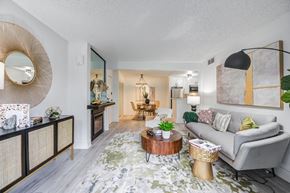 Woodland Hills apartment for rent - Fusion Warner Center luxury apartments in Woodland Hills ca living room with elegant natural decor - modern grey couch and mottled green, grey and blue rug.