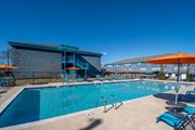 Nashville apartment for rent - The Canvas Apartments Nashville swimming pool with a blue tiled building in the background.