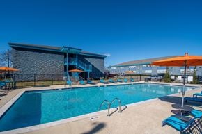 Nashville apartment for rent - The Canvas Apartments Nashville swimming pool with a blue tiled building in the background.