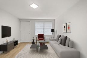 Hendersonville apartment for rent - Retreat at Indian Lake apartments in Hendersonville, TN living room with a grey sofa, a red chair, a black table, and a white door.