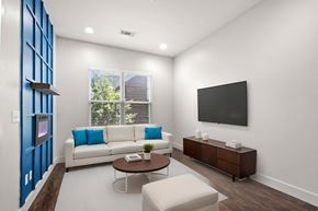 Nashville apartment for rent - State Street Flats 1 bedroom apartments Nashville modern living room with a white couch, a brown coffee table, an electric fireplace, and a flat-screen TV mounted on the wall.