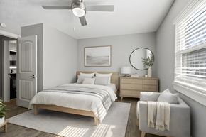 Jacksonville apartment for rent - A bedroom with a bed, dresser, and chair at Mandarin Bay Apartments.