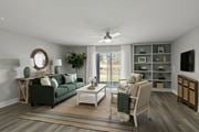 Jacksonville apartment for rent - A living room with a green couch, a white coffee table, and a large window with a view of the outside at Mandarin Bay Apartments.