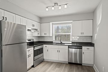 Jacksonville apartment for rent - A kitchen with white cabinets and a stainless steel refrigerator.