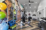 Orlando apartment for rent - Fusion Orlando fitness center with a variety of equipment and a motivational poster on the wall.