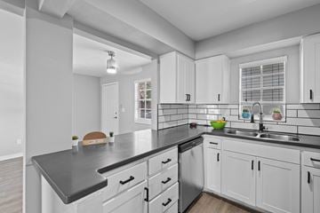 Lakeland apartment for rent - A modern kitchen with white cabinets and a black countertop.
