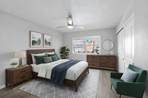 Lakeland apartment for rent - A bedroom with a bed, nightstand, and chair at Watermarc Apartments.