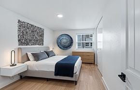 Nashville apartment for rent - The Canvas Apartments bedroom with a bed, nightstand, and artwork on the wall.