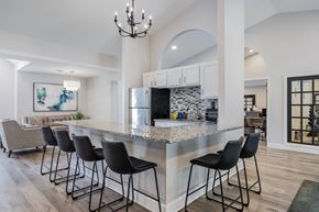 Reynoldsburg apartment for rent - A kitchen with a marble countertop and black barstools.