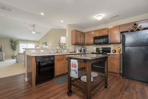 Blacklick townhouse for rent - A kitchen with a black refrigerator and wooden cabinets.