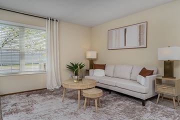 Hilliard apartment for rent - A living room with a white couch, a small table, and a painting on the wall.