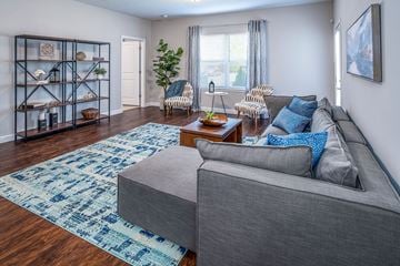 Etna apartment for rent - A living room with a grey couch and a blue rug.