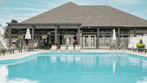 Pataskala apartment for rent - A large swimming pool in front of a building with a covered patio.