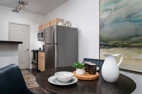 Canal Winchester apartment for rent - A modern kitchen with a refrigerator, a dining table with a bowl, a plant, and a jug.