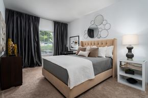 Canal Winchester apartment for rent - A bedroom with a large bed and a nightstand with a lamp.