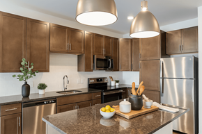 Cincinnati apartment for rent - A kitchen with brown cabinets and a granite countertop.