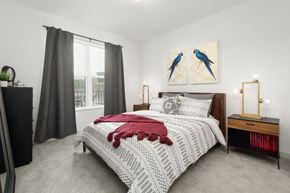 Cincinnati apartment for rent - A furnished bedroom at Madamore with carpeted flooring and a window for natural light.