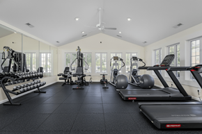 Hilliard apartment for rent - A spacious gym with a variety of equipment including treadmills, elliptical machines, and dumbbells.