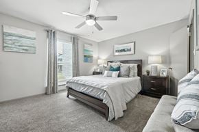 Fishers apartment for rent - A bedroom with a large bed and a ceiling fan.