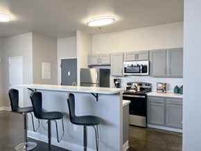 Philadelphia apartment for rent - A kitchen with white cabinets and black bar stools.