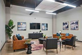 Philadelphia apartment for rent - A modern living room with a brown leather couch, a black armchair, and a wooden coffee table.