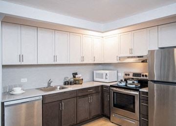 Brooklyn apartment for rent - A kitchen with brown cabinets and stainless steel appliances.