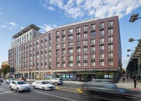 Brooklyn apartment for rent - a large brick building on the corner of a busy city street