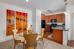 Queen Creek apartment for rent - A dining room with a table set for two and a painting of a forest scene on the wall.