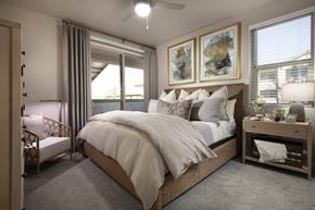Tucson apartment for rent - A bedroom with a large bed and a ceiling fan.