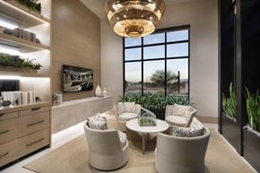 Tucson apartment for rent - A modern living room with a large window, a sofa, a chair, and a table.