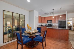 Queen Creek apartment for rent - A modern kitchen with wooden cabinets and a glass dining table.