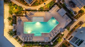 Tucson apartment for rent - A swimming pool surrounded by a patio and a garden.