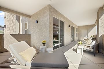 Marana apartment for rent - A modern living room with a white sofa and a grey cushion.