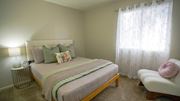 Tucson apartment for rent - A bedroom with a bed, a chair, and a lamp.
