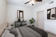 Goodyear apartment for rent - a bedroom with a large bed and a ceiling fan