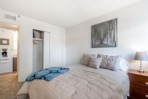 Yuma apartment for rent - A bedroom with a large bed and a painting on the wall.