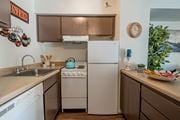 Yuma apartment for rent - A kitchen with a white fridge and a stove top oven.