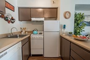 Yuma apartment for rent - A kitchen with a white fridge and a stove top oven.