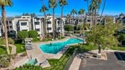 Yuma apartment for rent - A swimming pool surrounded by palm trees and apartment buildings.
